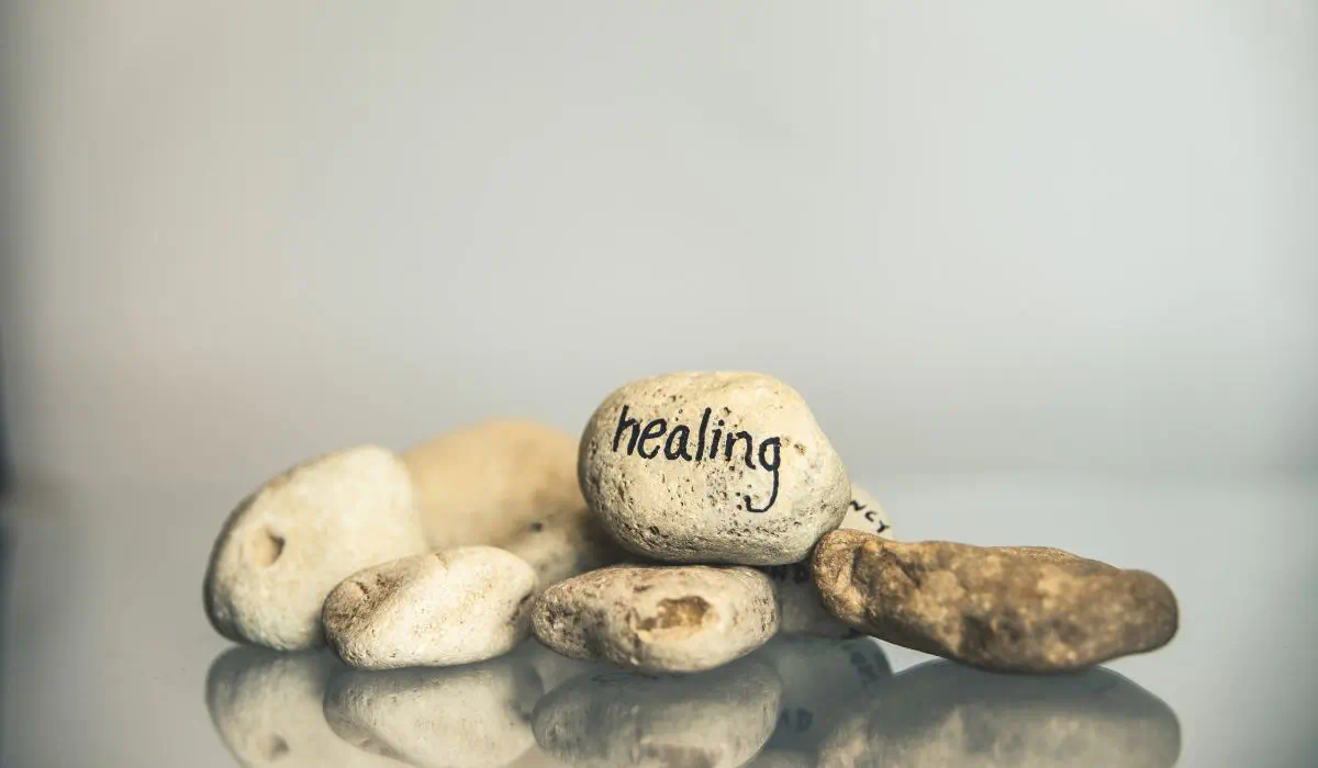 a pile of little white decorative stones with the words healing written on