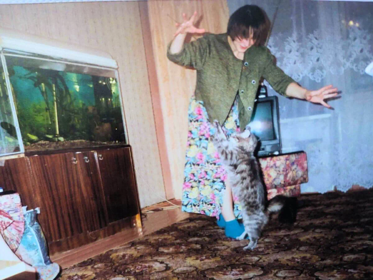 Mashka a cat playing with a young girl in their living room